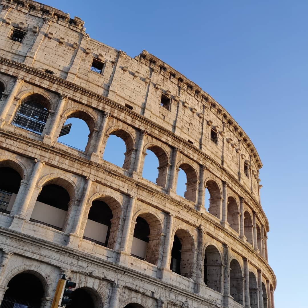 The Colosseum’s sunlit arches against a clear sky